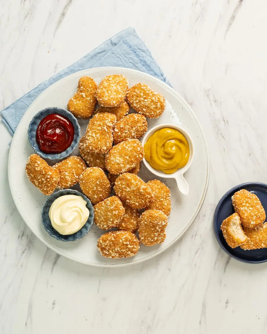 Nuggets de pollo BAS Frost en un plato con tres salsas